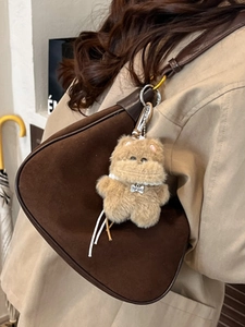 Brown suede shoulder bag with plush dog charm and leather strap for women