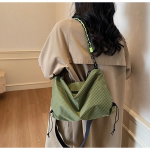 Detail of green checkered hobo bag with distinctive braided rope shoulder strap for women