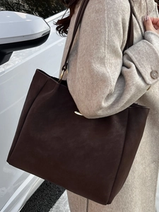 Minimalist large brown matte suede tote bag for women shown in a street style view