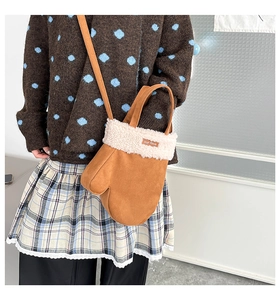 Sac peluche en forme de gant marron avec bordure en fausse fourrure porté par un mannequin