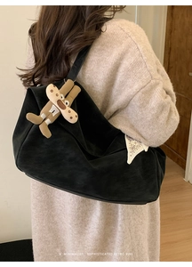 Detail of black suede tote bag with brown plush puppy charm and printed silk scarf