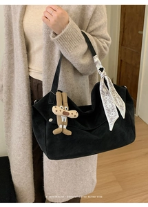 Close-up of black matte tote bag with puppy charm and decorative silk scarf detail