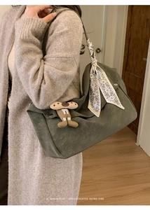 Detail of dark green tote bag with decorative vintage silk scarf and cute plush pendant