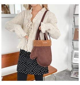 Détail du sac bandoulière en forme de gant avec bordure en peluche brune et texture mate