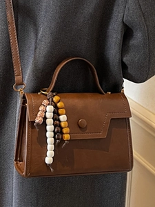 Sac bandoulière marron vintage avec poignée et accessoire décoratif en perles colorées