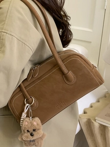 Retro brown bowling bag with white contrast stitching and cute plush bear charm
