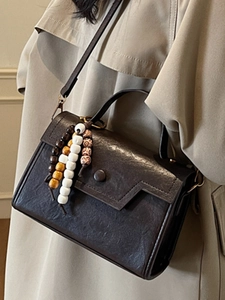 Sac bandoulière vintage marron foncé avec texture litchi et pendentif perlé tendance
