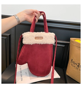 Détail du sac rouge en forme de gant avec bordure en fausse fourrure et étiquette