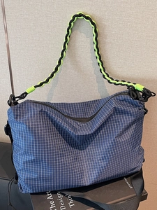 Blue checkered crossbody bag with contrasting woven rope handle for casual sports style