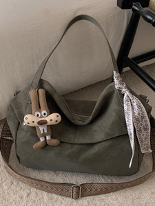Olive green tote bag in pebbled faux leather with stylish wide strap and plush charm