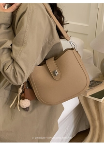 Detail of camel saddle bag with litchi texture leather and plush ice cream charm
