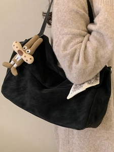 Chic black oversized tote bag in faux suede with decorative scarf and plush charm