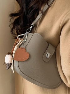 Chic taupe pebbled leather saddle bag with silver clasp and cute heart pendant for women