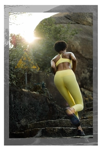Outdoor shot of a woman in high waist yellow yoga leggings and racerback sports bra set