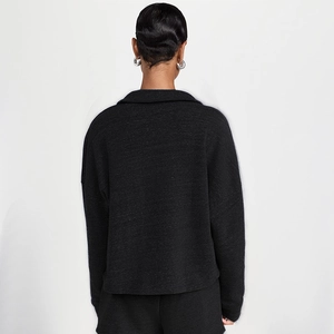 Rear view of loose-fit black long-sleeved pullover with dropped shoulders and collar detail