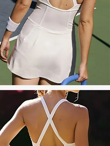 Detail of white tennis dress with criss-cross back straps and wavy hem on a sunny court
