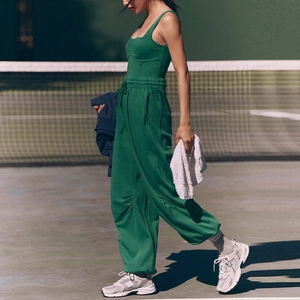 Detail of dark green ribbed athletic jumpsuit showing drawstring waist and wide leg cut