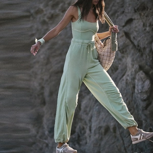 Detail of sage green yoga bodysuit with racerback and drawstring waist for fitness
