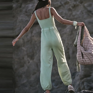 Close-up of mint green sports jumpsuit featuring thin straps and elastic waist detail