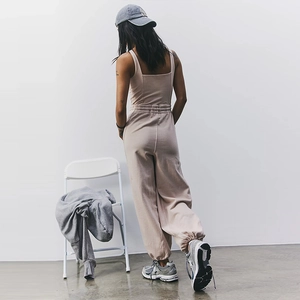 Detail of oatmeal ribbed knit yoga jumpsuit featuring a cross-back design and slim fit