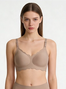 Detailed close-up of nude seamless bra with scalloped wavy edges on female model