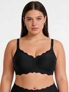 Close-up of black seamless bra featuring scalloped wave edges and adjustable straps on model