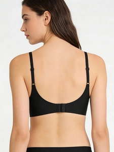 Detail view of seamless black wireless bra showing adjustable straps and back closure