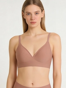 Detail view of seamless nude-pink wireless bra and matching panties set on model