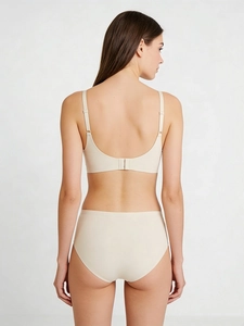 Detail view of seamless beige lingerie set showing back closure and sleek fabric texture