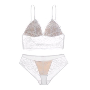 Détail de la broderie en dentelle florale blanche sur l'ensemble soutien-gorge et culotte