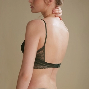 Detail of deep green lace bralette featuring adjustable straps and delicate hollow-out back