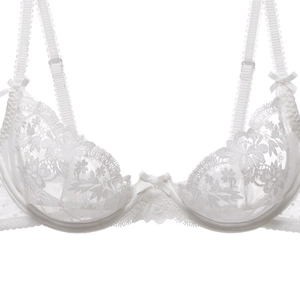 Close-up of white floral lace bra with delicate embroidery and adjustable bow straps