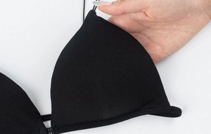 Detalle de sujetador triangular negro sin costuras con tejido de punto fino y tirante fino