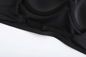 Detail van verstelbare zwarte bandjes met fijne stiksels op gladde lingeriestof voor dames
