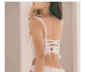Détail d'un soutien-gorge en dentelle blanche avec trois agrafes et bords à volants