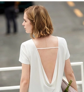 Detail of white deep V-back top with elegant horizontal strap and smooth silk-like texture