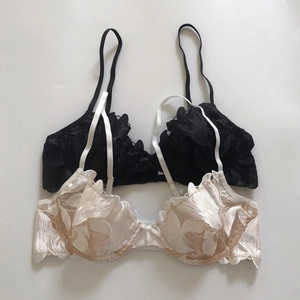 Close-up of black and beige lace embroidered bras featuring elegant petal scalloped edges