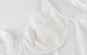 Gros plan détaillé d'un corset en dentelle blanche avec mesh et bords à volants