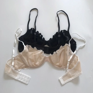 Detailed view of sheer lace bras in black and beige with adjustable straps and mesh