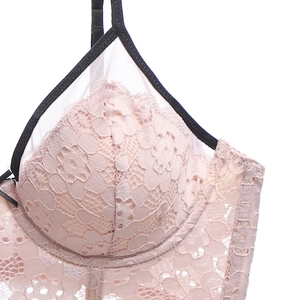 Détail en gros plan de dentelle florale rose avec liseré noir sur soutien-gorge