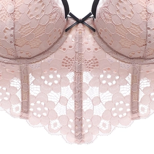 Détail du bustier en dentelle rose pâle avec bretelles noires et baleines de maintien