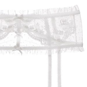 Detail of white lace garter belt with floral embroidery and delicate silk bows