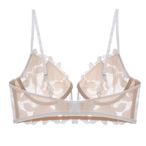 Close-up of beige floral lace embroidery and adjustable straps on deep V lingerie set