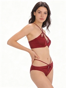 Detail of wine red satin lingerie set with lace patchwork and crisscross straps