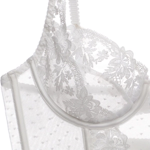 Détail de broderie florale blanche en dentelle et tulle sur un soutien-gorge corset