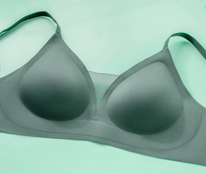 Detail of dark green seamless bra showing breathable mesh patchwork and adjustable strap