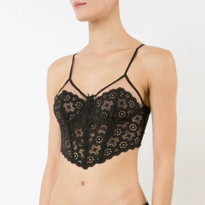 Détail d'une bralette en dentelle noire avec coutures corset et fines bretelles