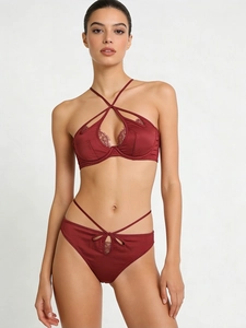 Detail of burgundy satin lingerie set with delicate eyelash lace and criss-cross straps