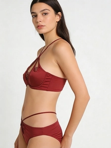 Detailed side view of deep red satin bra with delicate eyelash lace and strappy details