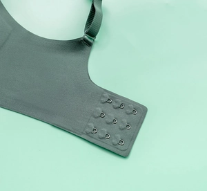 Detail view of the seamless green bra featuring three-row back hooks and adjustable straps